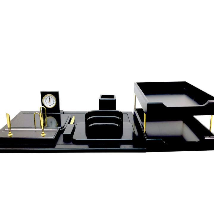 Black office desk set with clock, pen holder, and tray on a white background