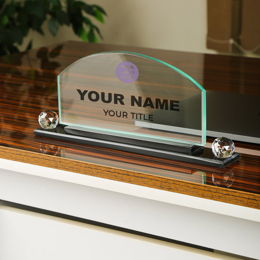 Glass nameplate with customizable text on a wooden stand