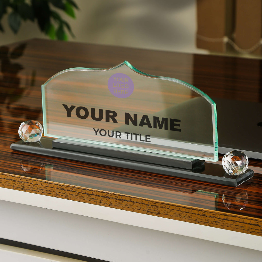Glass nameplate with customizable text on a wooden surface