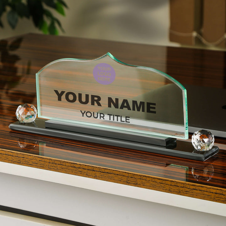 Glass nameplate with customizable text on a wooden surface