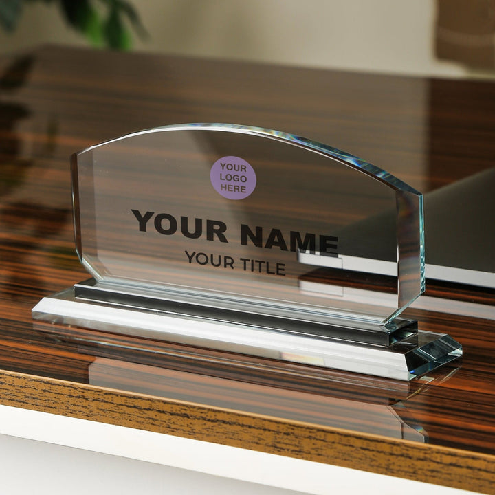 Glass nameplate with customizable text on a wooden surface