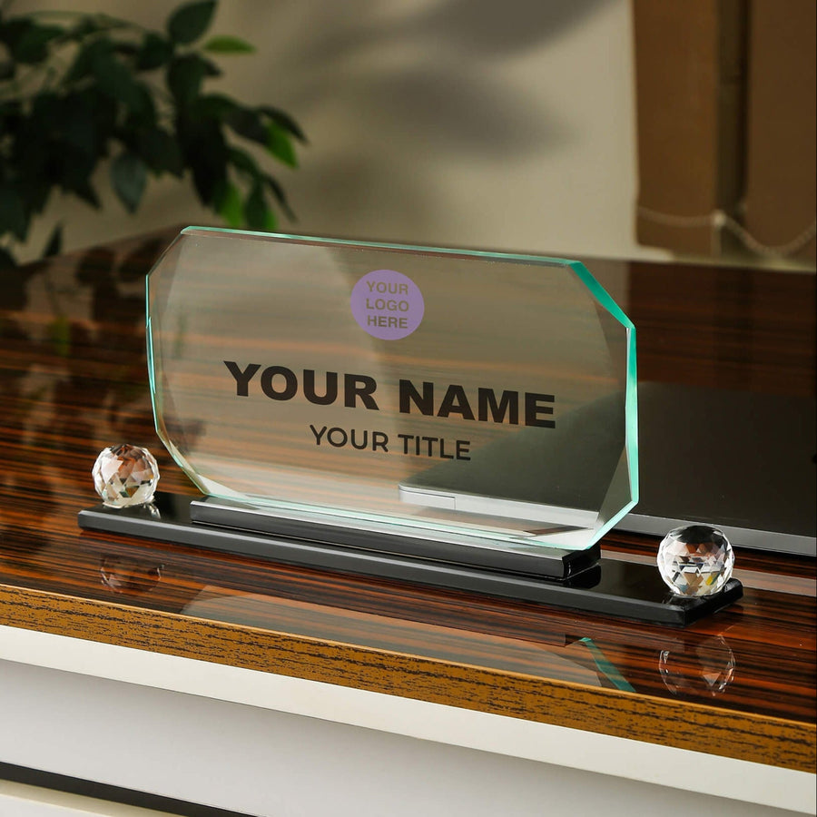 Glass nameplate with customizable text on a wooden surface