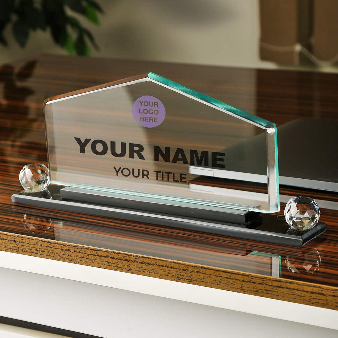 Glass nameplate with customizable text on a wooden surface