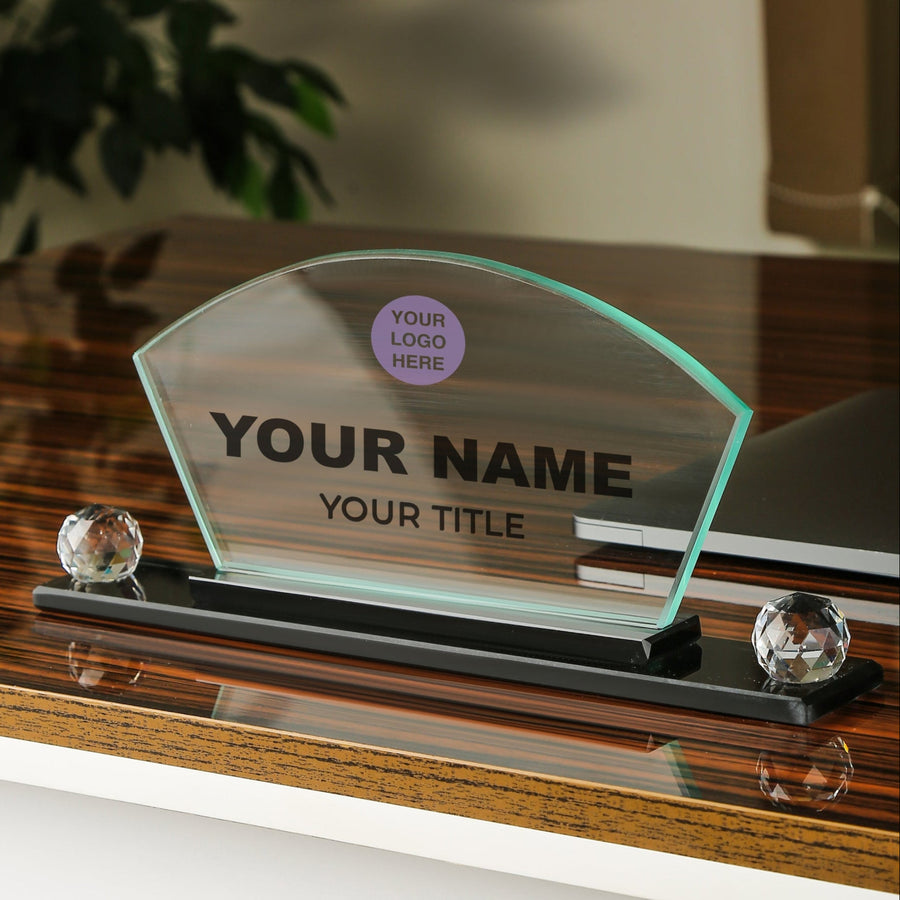 Personalized glass nameplate on a wooden surface with customizable text.