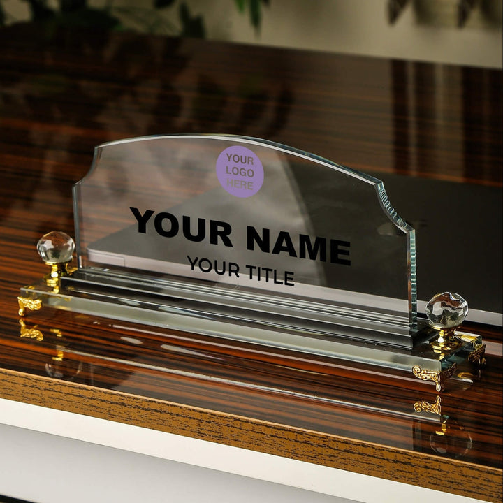 Glass nameplate holder with customizable text on a wooden surface